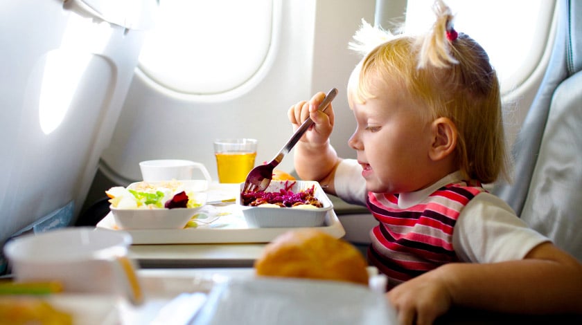 Criança comendo dentro do avião
