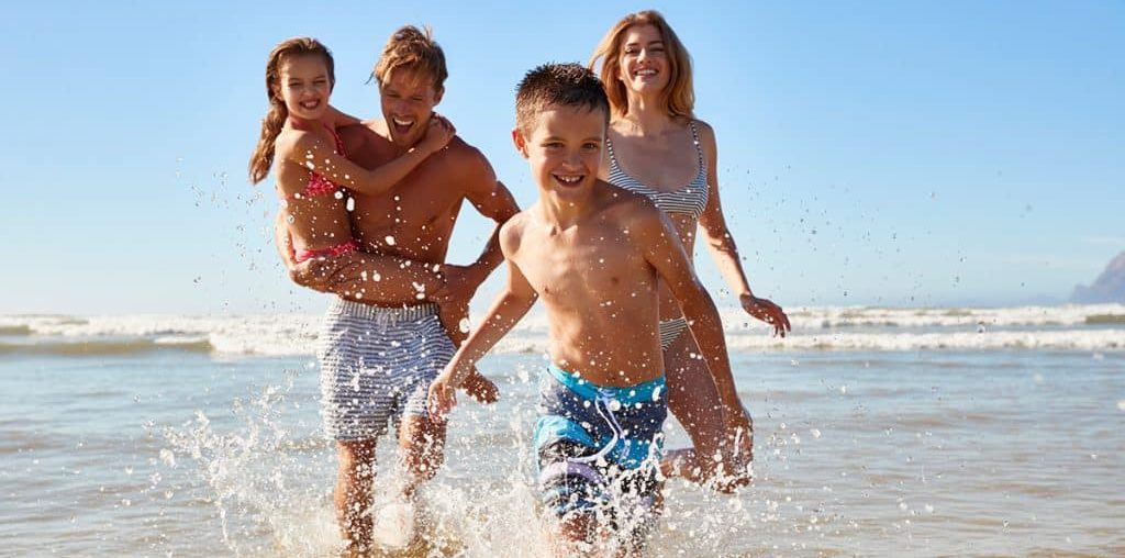 família correndo na praia