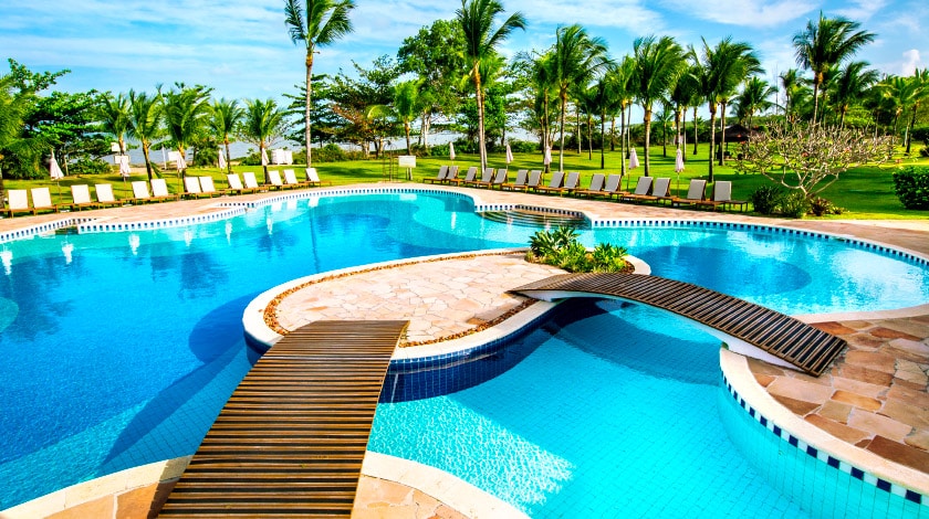 Piscina e coqueiros do resort All-Inclusive Vila Angatu, na Bahia