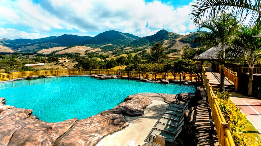 Piscina e montanhas ao fundo, na Fazenda Vale da Mantiqueira