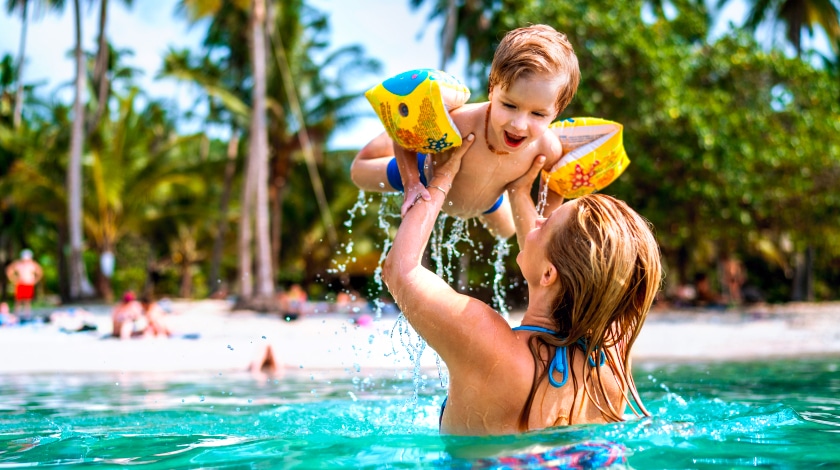 Mãe e filho se divertindo na praia