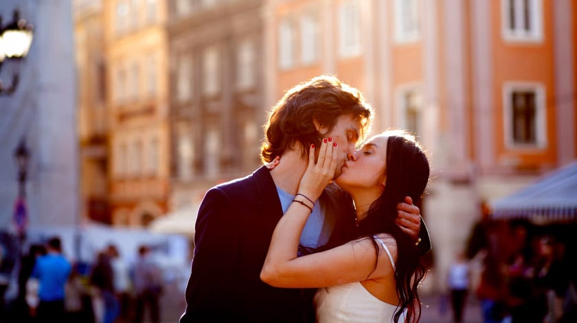 Casal se beijando na rua, durante uma viagem